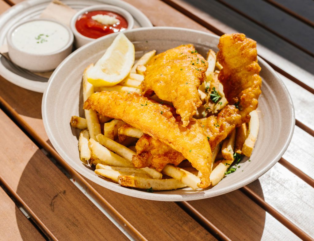 plate of fried fish and chips with lemon wedge garnish